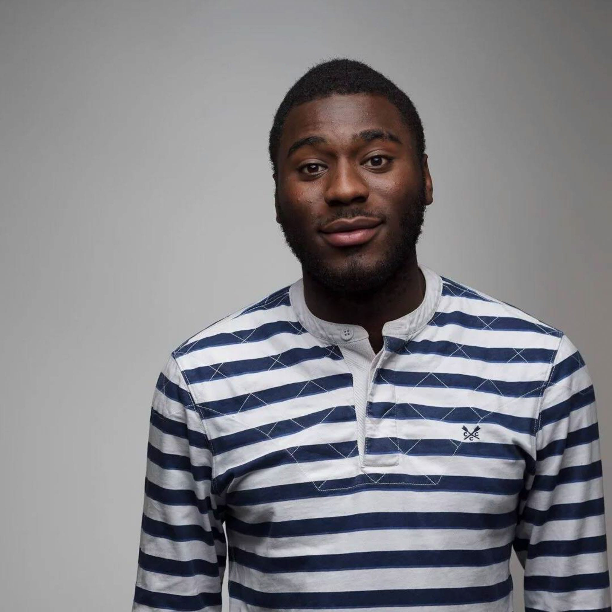 Carl Anka, wearing a striped long-sleeve shirt. The background is a soft gray, creating a neutral and warm atmosphere around him.